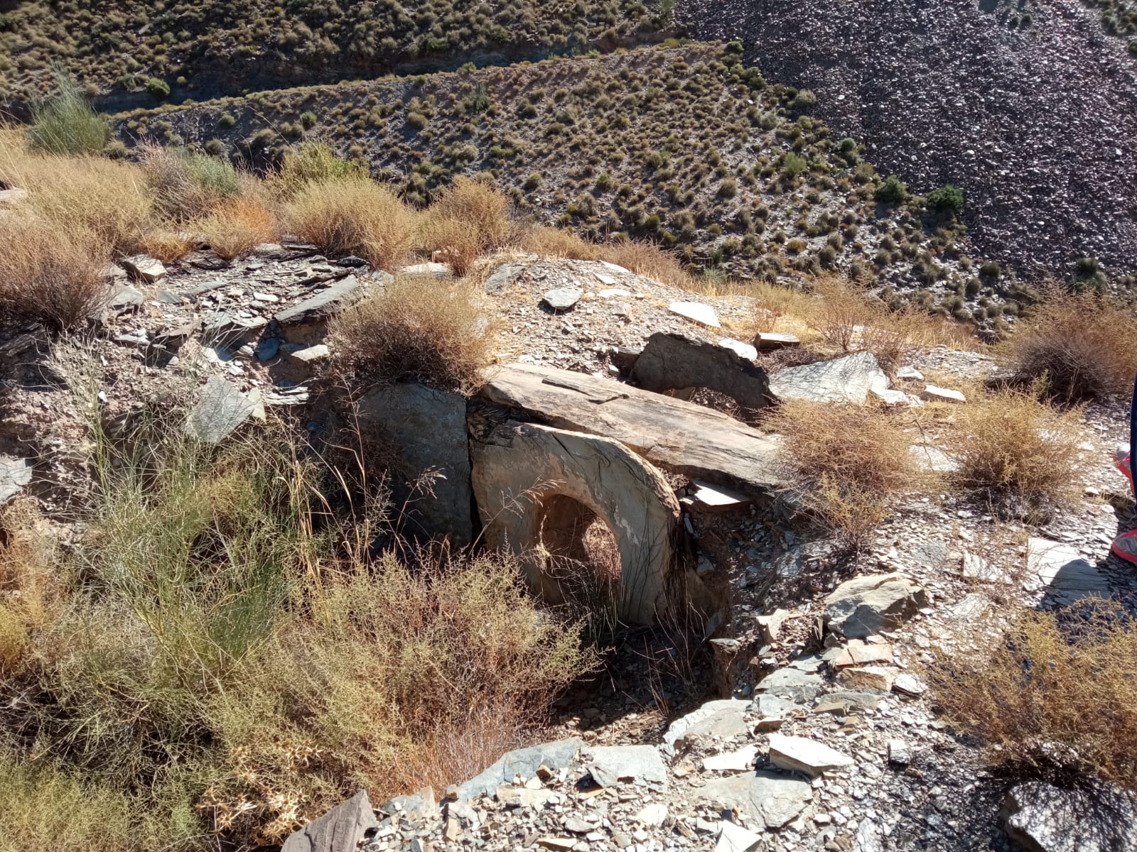 Sepultura tipo tholos con entrada en buen estado de conservación en forma de lajas de pizarra perforadas Sepultura tipo tholos con entrada en buen estado de conservación en forma de lajas de pizarra perforadas