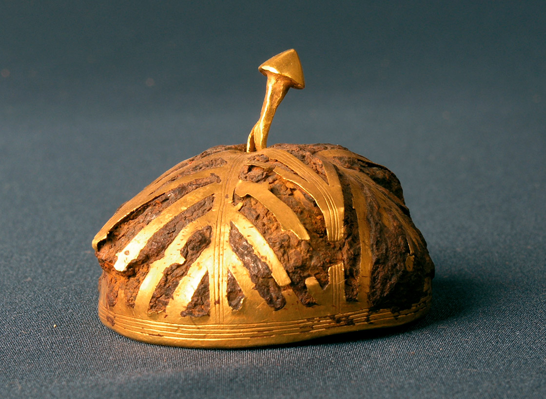 Semiesfera hueca ¿casco? de hierro recubierto de láminas de oro. Se puede observar como la corrosión del hierro ha cubierto y deformado algunas láminas de oro. Fotografía Museo de Villena (Alicante). Sin escala, diámetro máximo 4,5 cm. - Semiesfera hueca ¿casco? de hierro recubierto de láminas de oro. Se puede observar como la corrosión del hierro ha cubierto y deformado algunas láminas de oro. Fotografía Museo de Villena (Alicante). Sin escala, diámetro máximo 4,5 cm. -